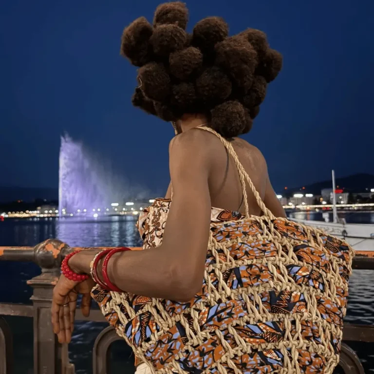 Sac cabas en raphia et wax porté à l'épaule au bord du lac, motifs orange et bleus