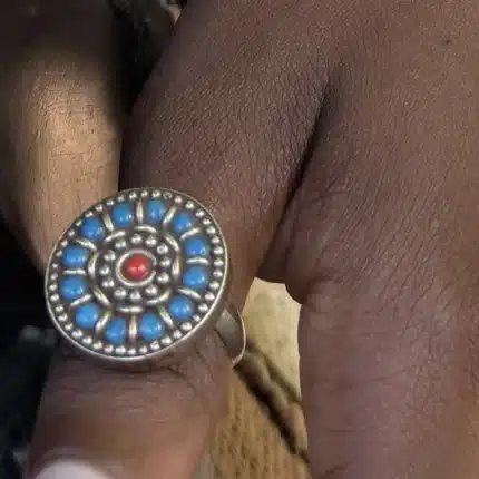 Bague ethnique marocaine rosace de turquoises et corail portée au doigt