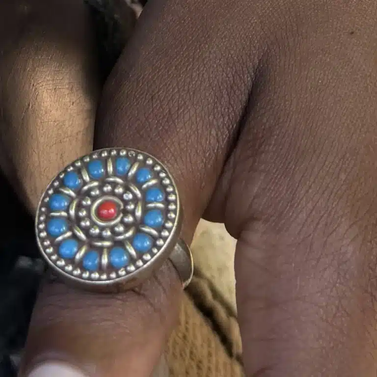 Bague ethnique marocaine rosace de turquoises et corail portée au doigt