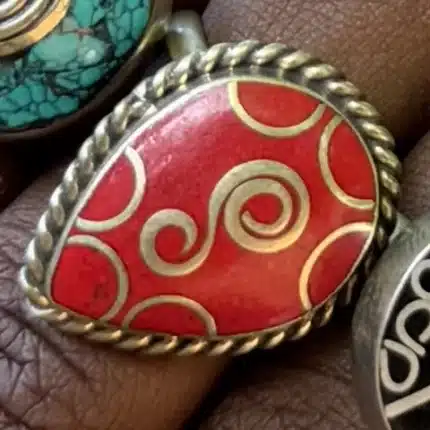 Bague artisanale cabochon de corail rouge gravé de spirales dorées, vue de détail