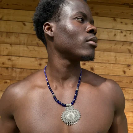 Collier berbère en argent, médaillon soleil et perles de lapis bleu, porté à même la peau