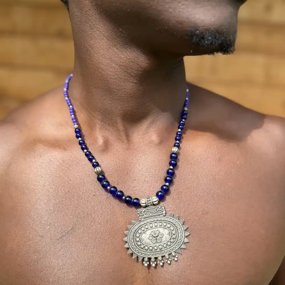 Collier berbère en argent, médaillon soleil et perles de lapis bleu, porté à même la peau