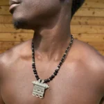 Collier berbère en argent, plaque gravée et perles noires, porté à même la peau
