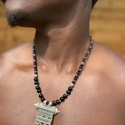 Collier berbère en argent, plaque gravée et perles noires, porté à même la peau