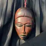 Collier pendentif masque africain en bois acajou au visage lisse, porté en sautoir, AKU Creation, vue 5
