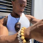 Collier pendentif masque africain en bois brun sculpté, porté en sautoir, AKU Creation, vue 7