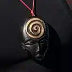 Collier pendentif masque africain en bois noir orné d'une spirale dorée, AKU Creation