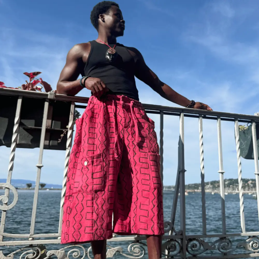 Short baggy en bogolan rose à motifs géométriques noirs, porté en extérieur au soleil