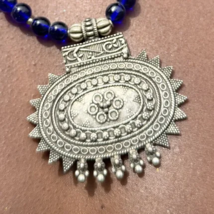 Pendentif médaillon soleil en argent ciselé sur perles de lapis bleu, collier berbère AKU Creation