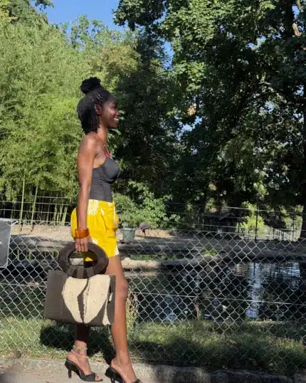 Short d'été unisexe en coton jaune porté avec un sac artisanal